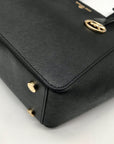 Black handbag with gold accents on a light gray background