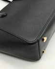 Black handbag with gold hardware on a white background