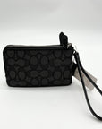 Black patterned wristlet with a strap on a white background