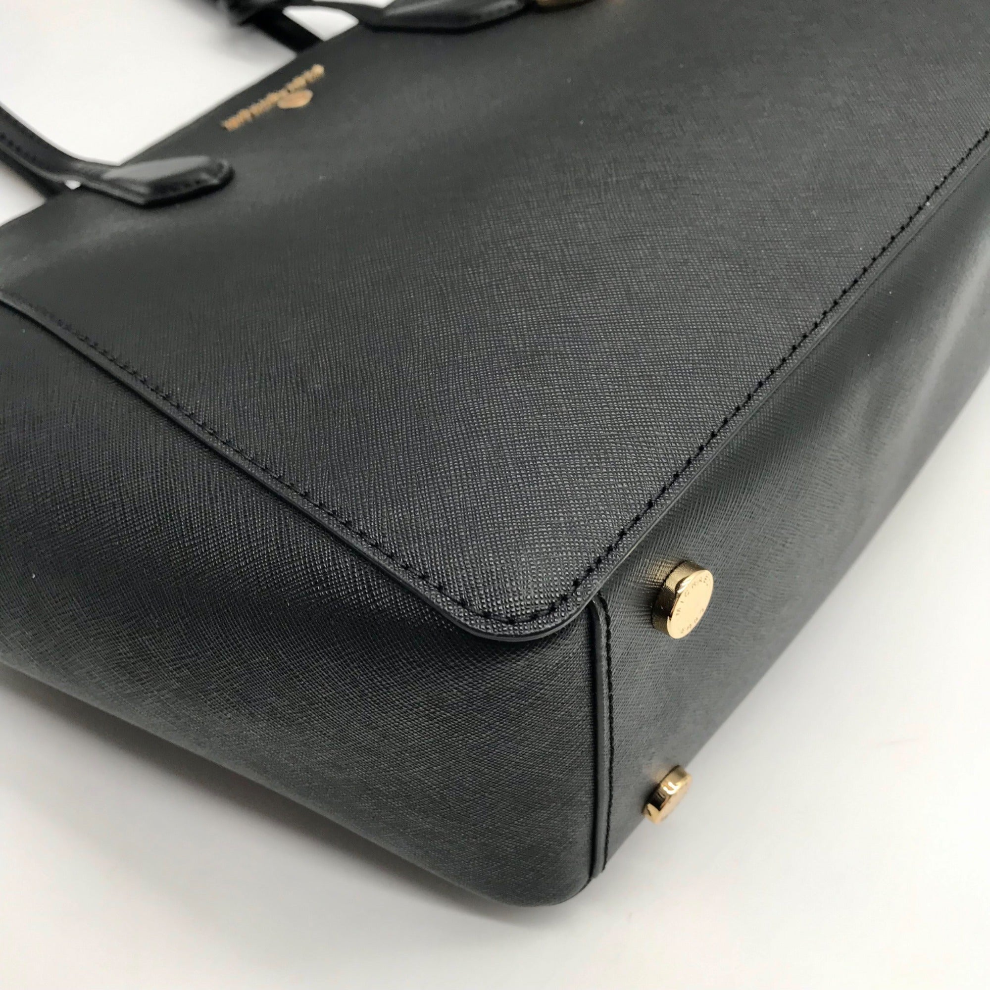 Black handbag with gold accents on a white background
