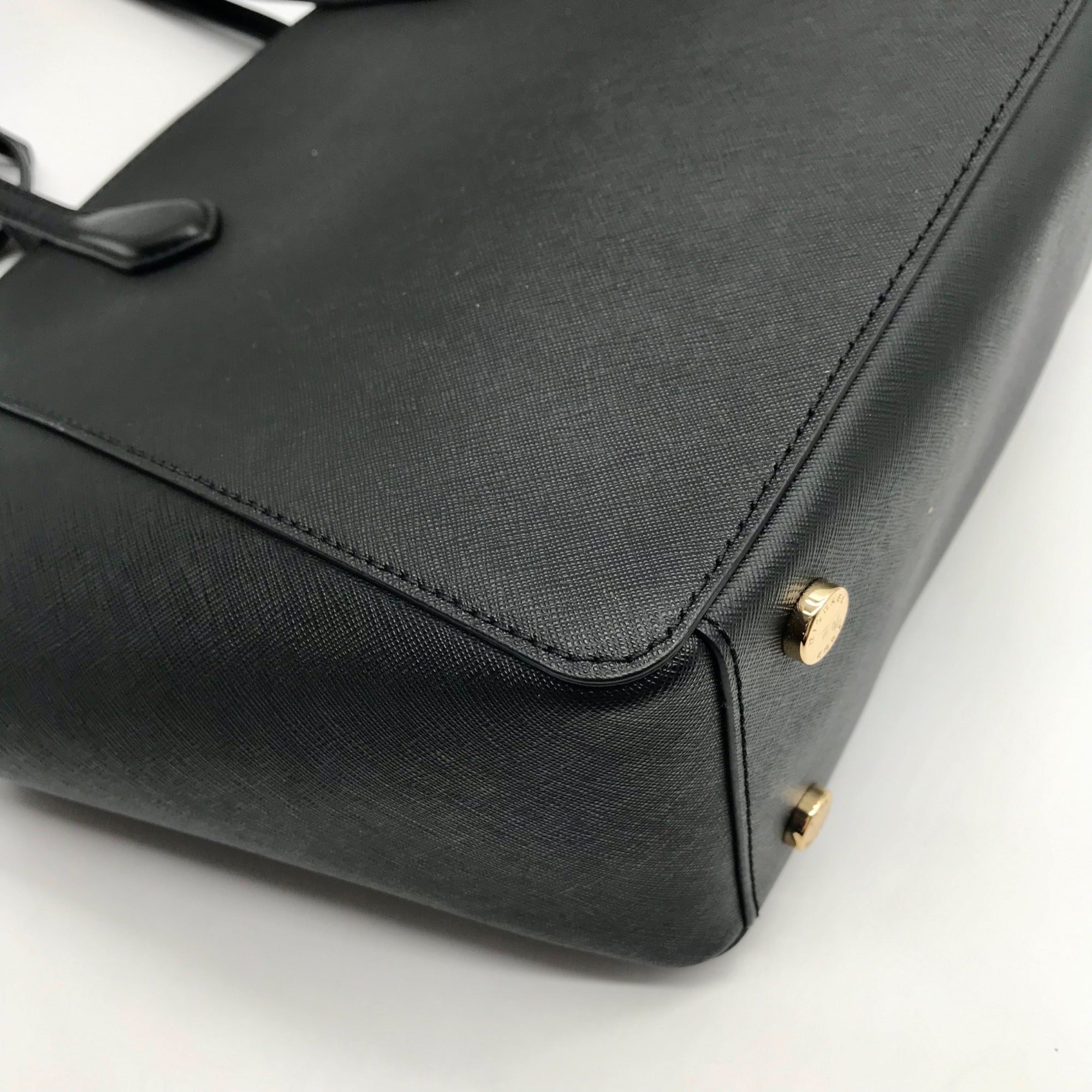 Black handbag with gold hardware on a white background