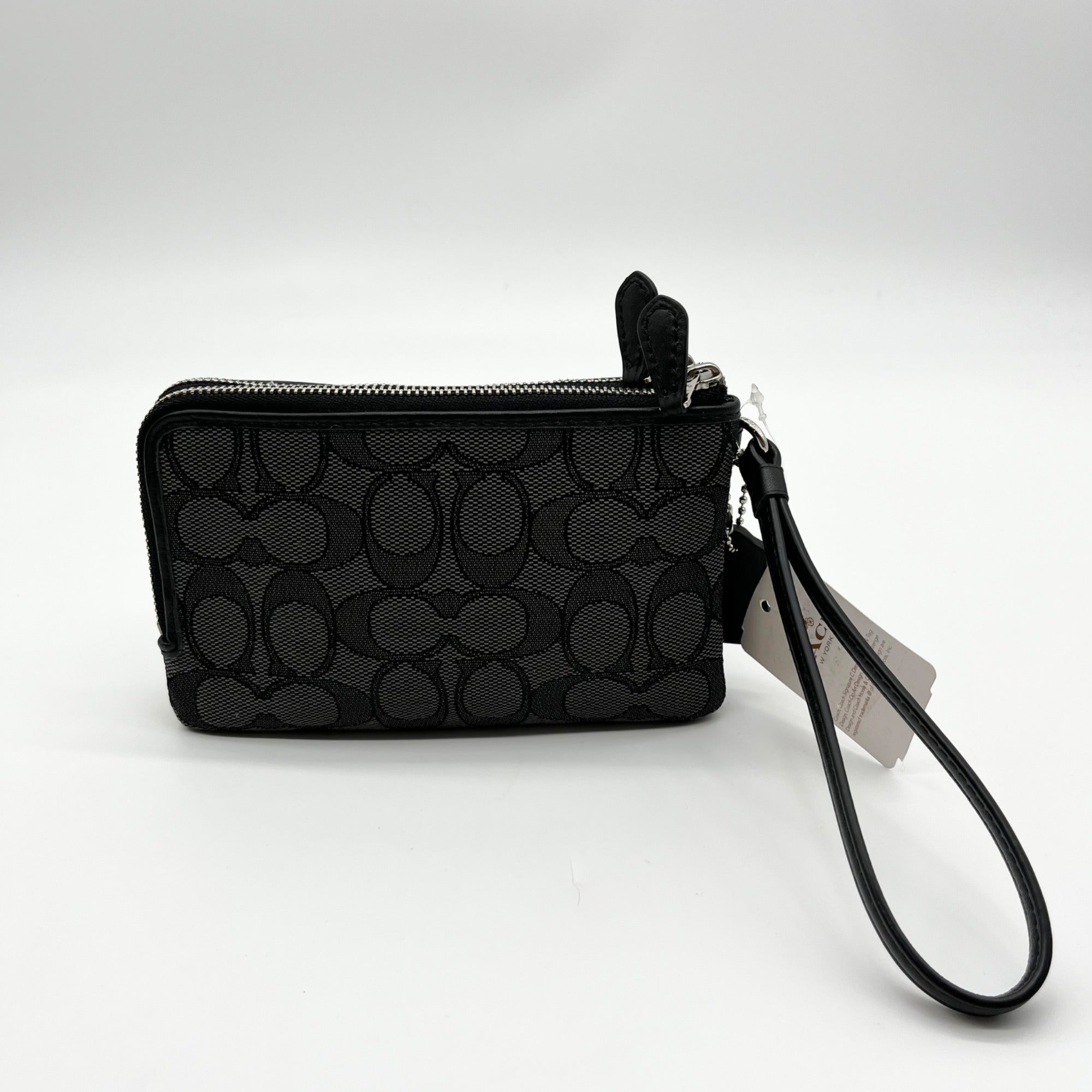 Black patterned wristlet with a strap on a white background