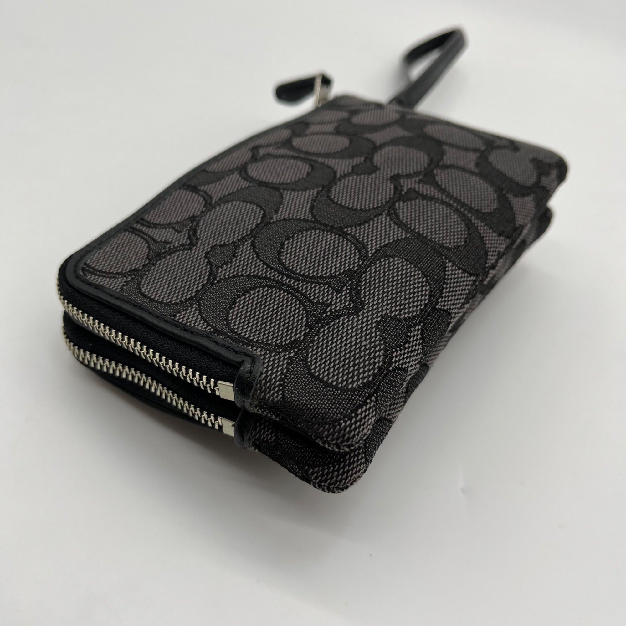 Black patterned wallet with a zipper on a white background